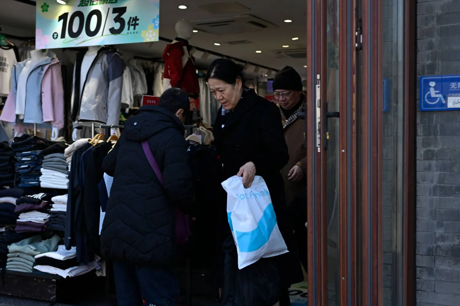  People visit a clothes shop in Beijing on March 9, 2026. (AFP) 