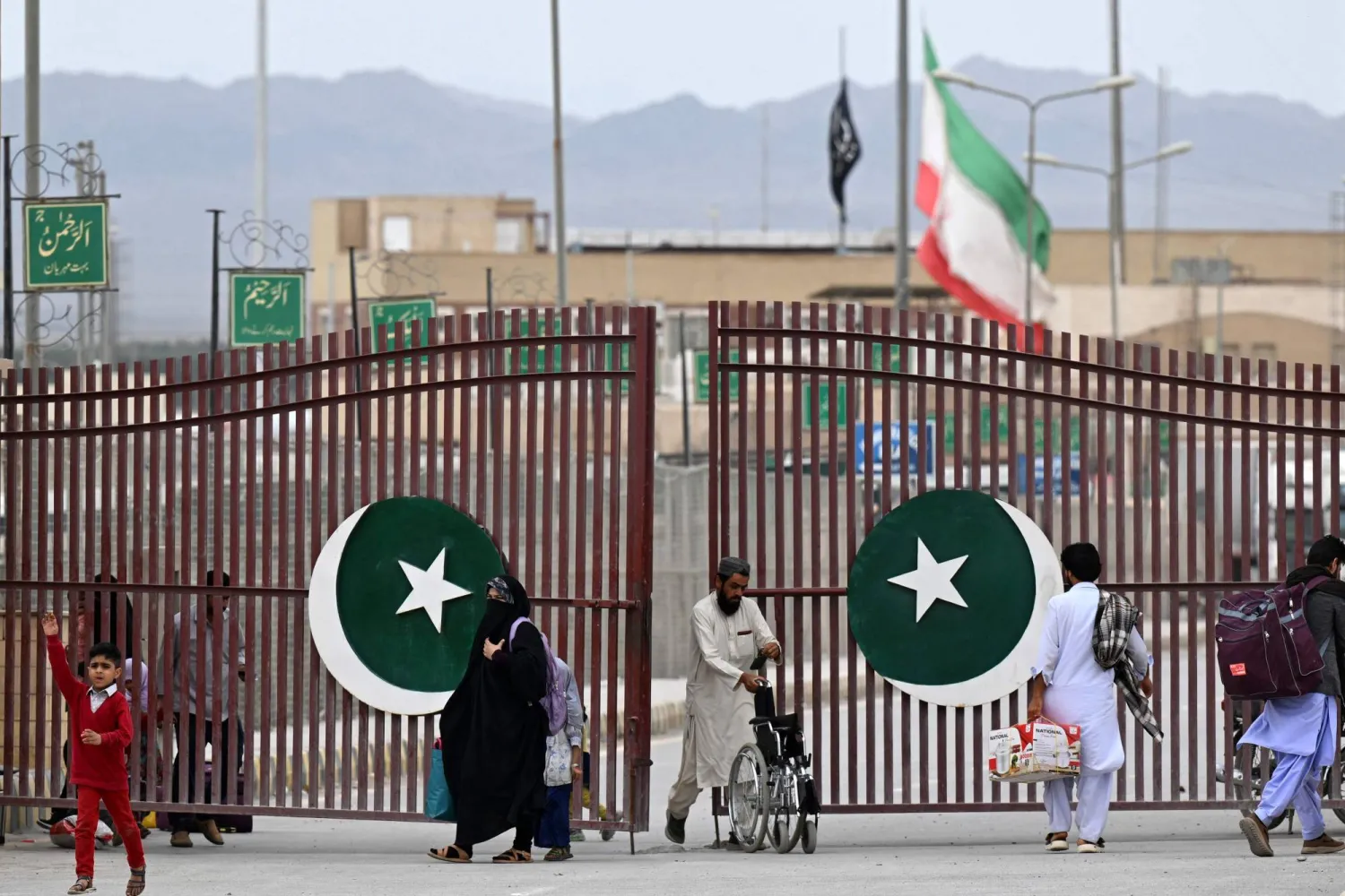 Pakistanis walk across the Taftan border as they return from Iran, in Balochistan province, on March 9, 2026 amid ongoing US-Israel strikes on Iran. (AFP)