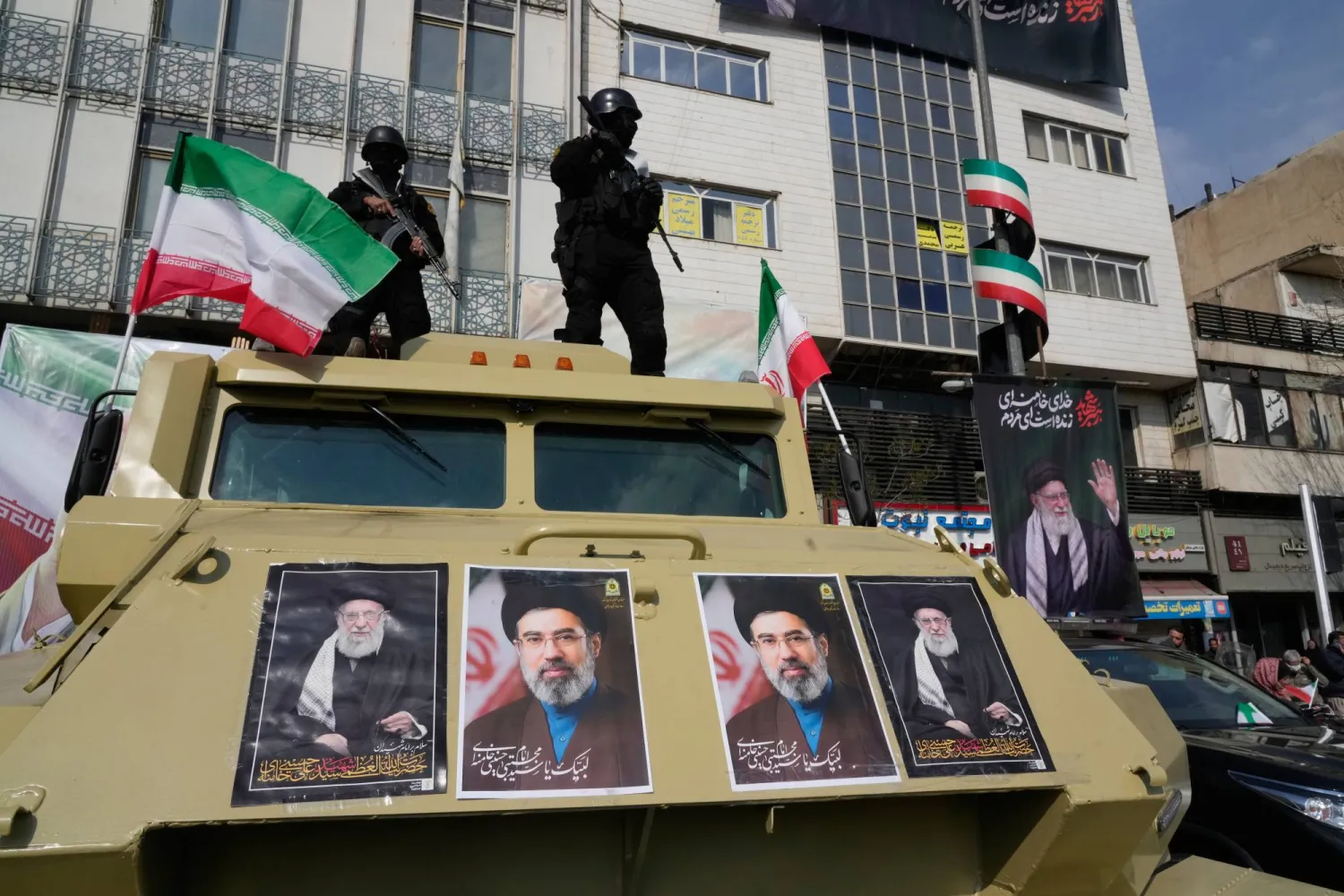 Policemen stand on top of their car with pictures of the late Iranian Supreme Leader Ayatollah Ali Khamenei, right and left, and his son Ayatollah Mojtaba Khamenei, the successor to him, center, during a rally to support him in Tehran, Iran, Monday, March 9, 2026. (AP Photo/Vahid Salemi)