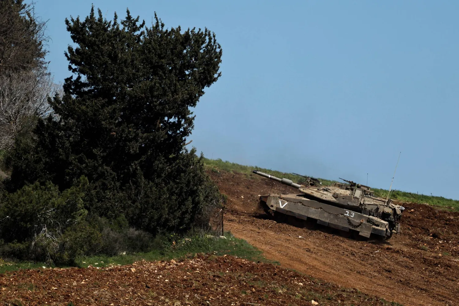 دبابة إسرائيلية تناور على الجانب الإسرائيلي من الحدود مع لبنان (رويترز)