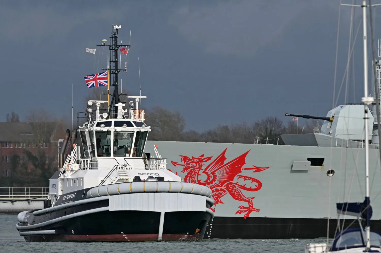 قاطرة «SD Tempest» البريطانية بجانب سفينة «HMS Dragon» وهي مدمرة دفاع جوي تابعة للبحرية الملكية البريطانية في قاعدة بورتسموث البحرية الملكية على الساحل الجنوبي لإنجلترا 10 مارس 2026 (أ.ف.ب)
