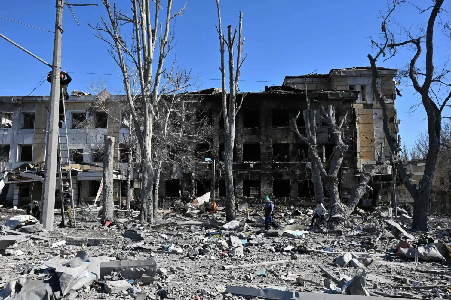 Yetkililerin Ukrayna ordusunun Rusya kontrolündeki Donetsk'e düzenlediği saldırı olarak nitelendirdiği son bombardımanın ardından hasar gören bir çocuk kliniğinin önündeki elektrik kabloları onarılıyor (AFP)