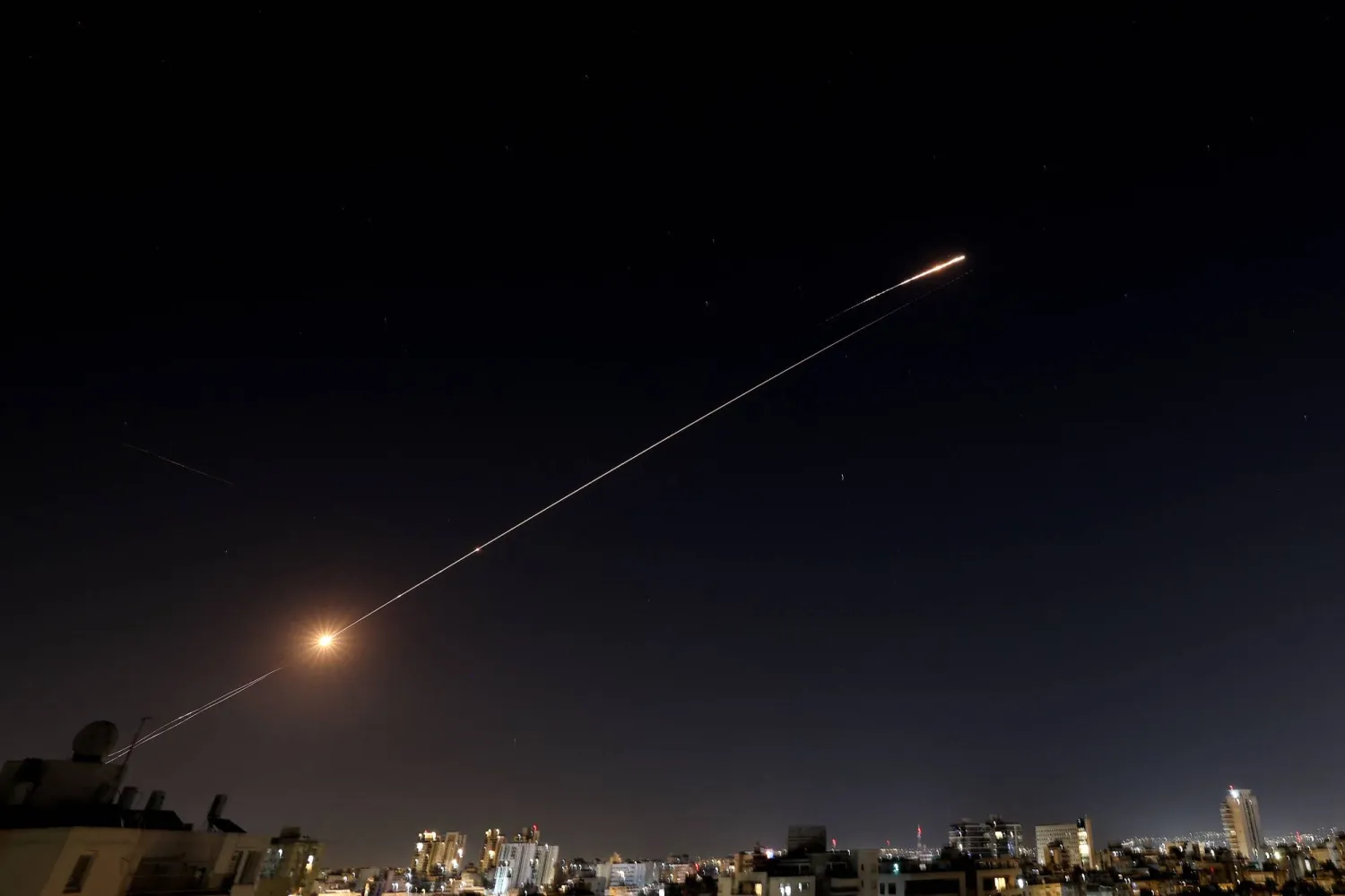 Rocket trails are seen in the sky above the Israeli center coastal city of Netanya amid a fresh barrage of Iranian missile attacks on March 11, 2026. (AFP)