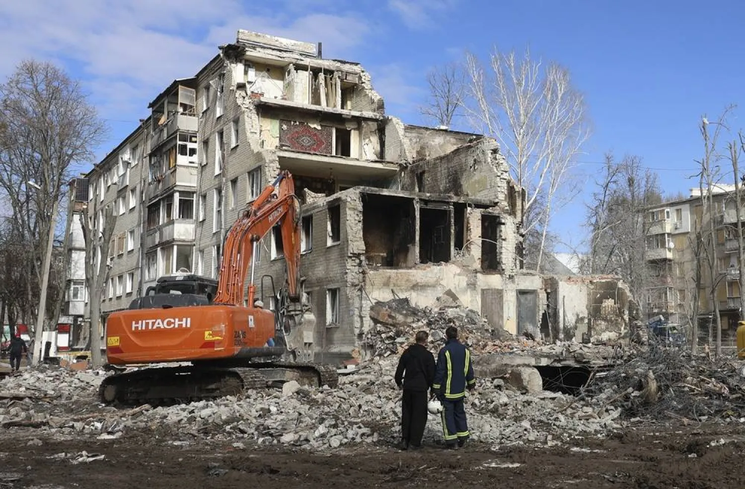 A local man and a rescuer stand near the rubble at the site of a residential building destroyed by a Russian strike on 07 March, in Kharkiv, northeastern Ukraine, 09 March 2026. (EPA)