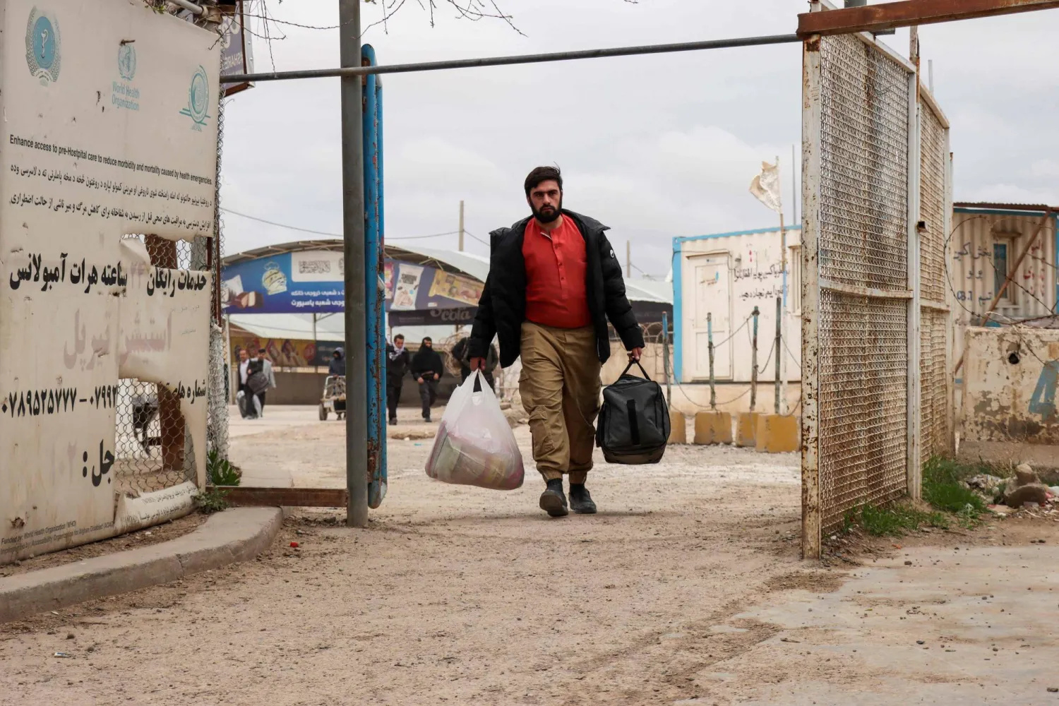  An Afghan national arrives with his belongings at the Islam Qala border crossing between Afghanistan and Iran in Herat province on March 10, 2026, upon his arrival from Iran amid the Middle East war. (AFP) 