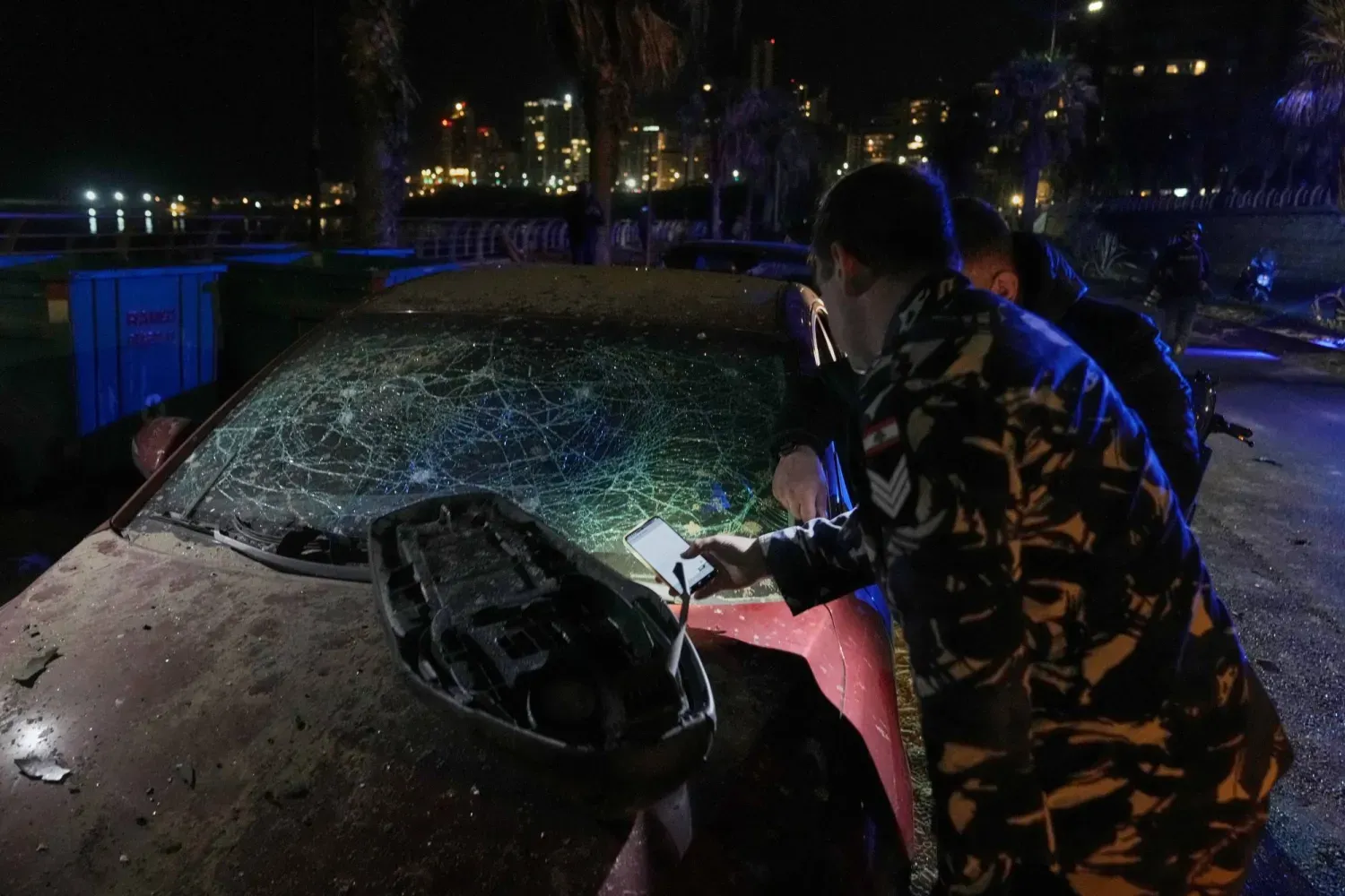 Beyrut'un Ramlet el-Bayda bölgesinde İsrail hava saldırısında hasar gören aracı inceleyen bir güvenlik görevlisi (AP)
