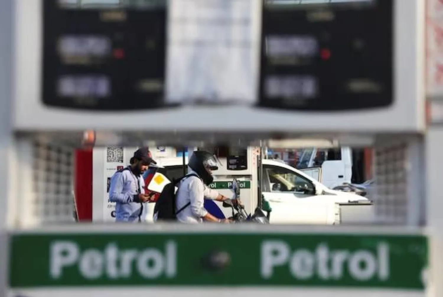 مواطن يغادر بعد تزويد دراجته بالوقود في محطة وقود بنيودلهي (رويترز)