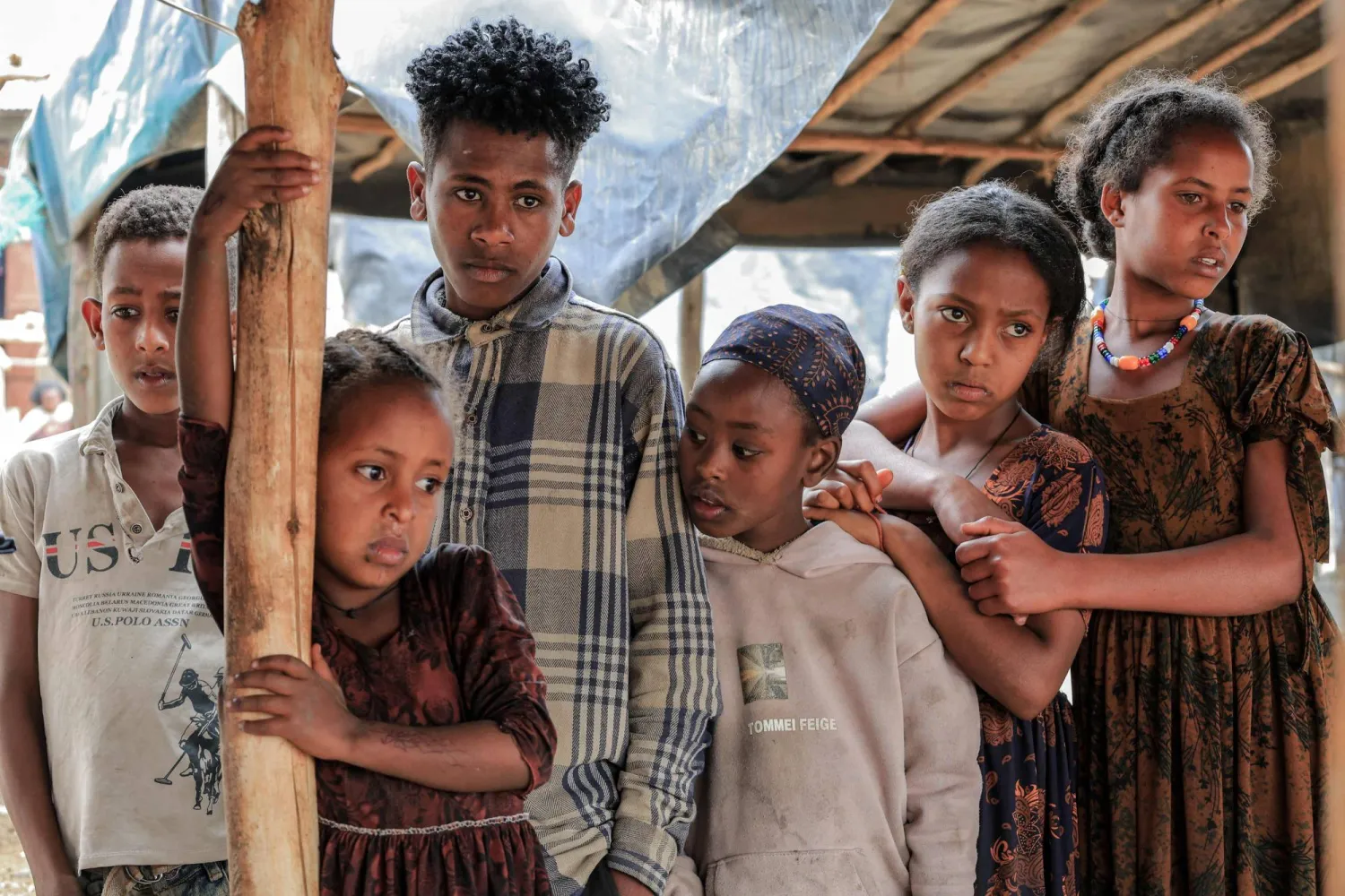 Children gather at a market stall to collect goods in Chercher, Southern Tigray, on March 4, 2026. (Photo by Abel Gerezgiher / AFP)