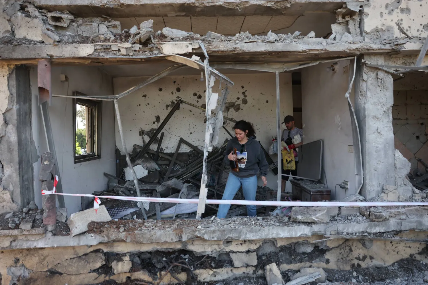 سكان يتفقدون أضراراً بعد أن أصاب صاروخ أطلقه «حزب الله» من لبنان منزلاً بالقرب من مدينة نتانيا إسرائيل 12 مارس 2026 (إ.ب.أ)