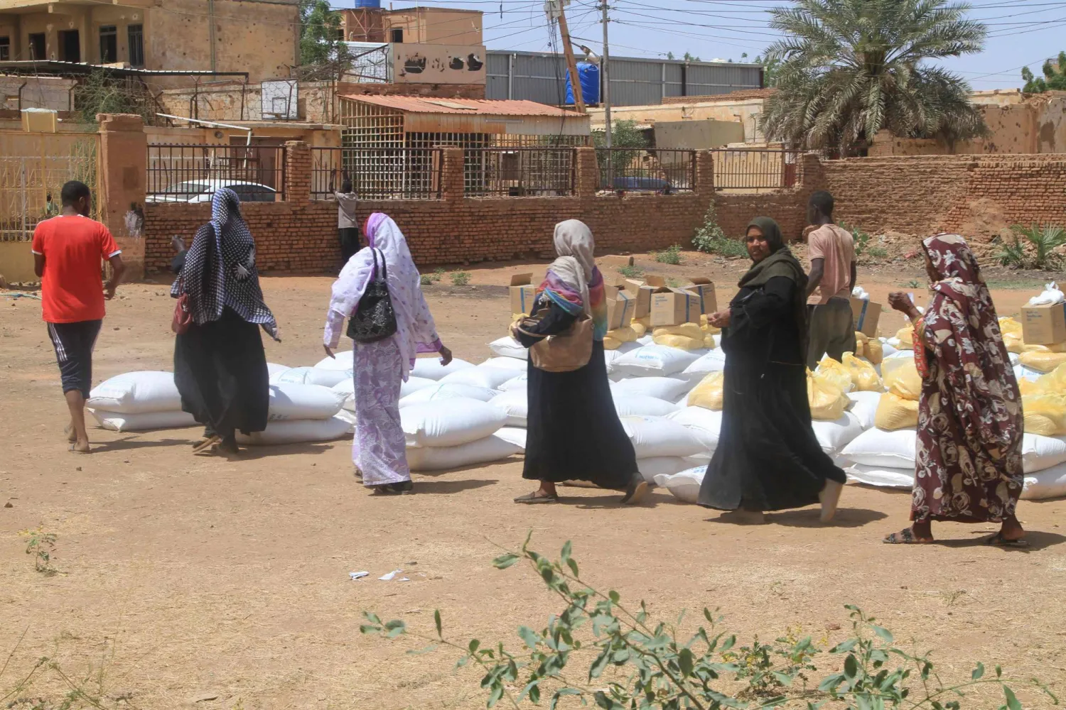 Residents receive aid from World Food Programme (WFP) at Al-Omada neighbourhood of Omdurman, the twin city of Khartoum on March 11, 2026. (Photo by Ebrahim Hamid / AFP)