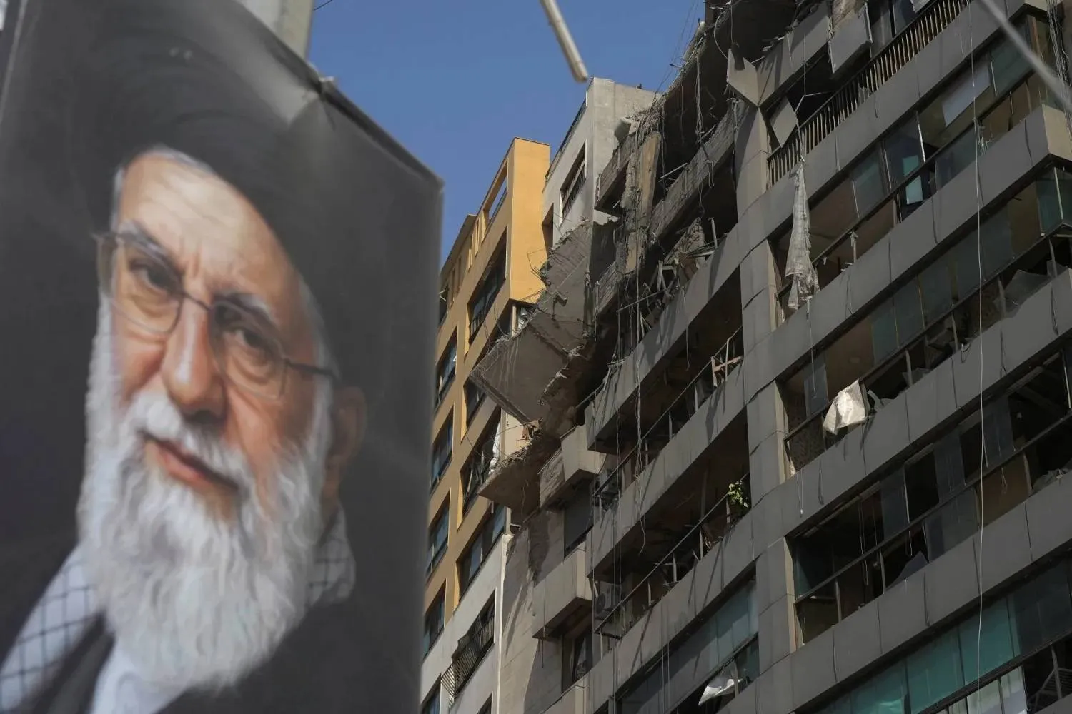 A damaged building in Beirut’s southern suburbs after an Israeli strike on the area, with a large portrait of Iran’s late Supreme Leader Ali Khamenei displayed on it (Reuters)
