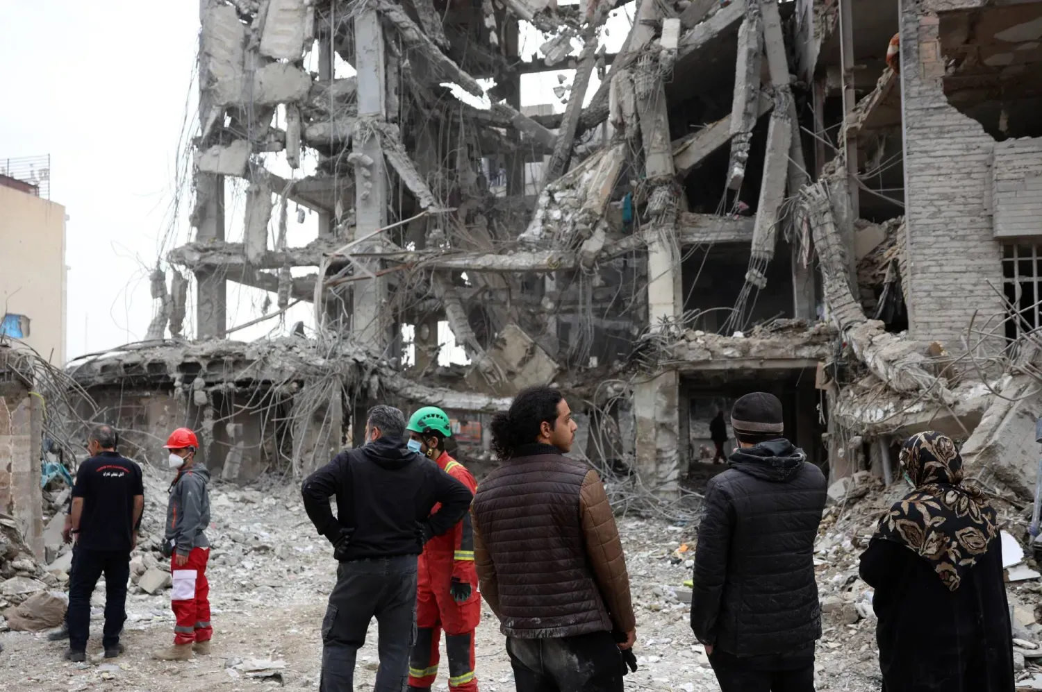 İranlılar dün Tahran'ın merkezinde ABD-İsrail bombardımanı sonucu hasar gören konut binalarını inceliyor (EPA)