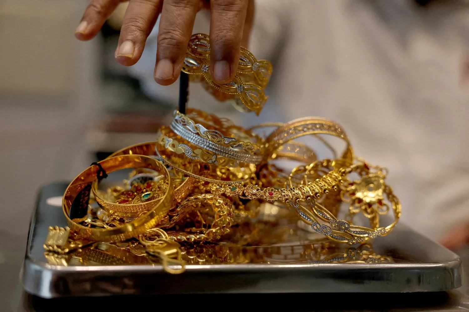FILE PHOTO: A goldsmith weighs gold jewelry inside a showroom in Ahmedabad, India, July 31, 2025. REUTERS/Amit Dave/File Photo