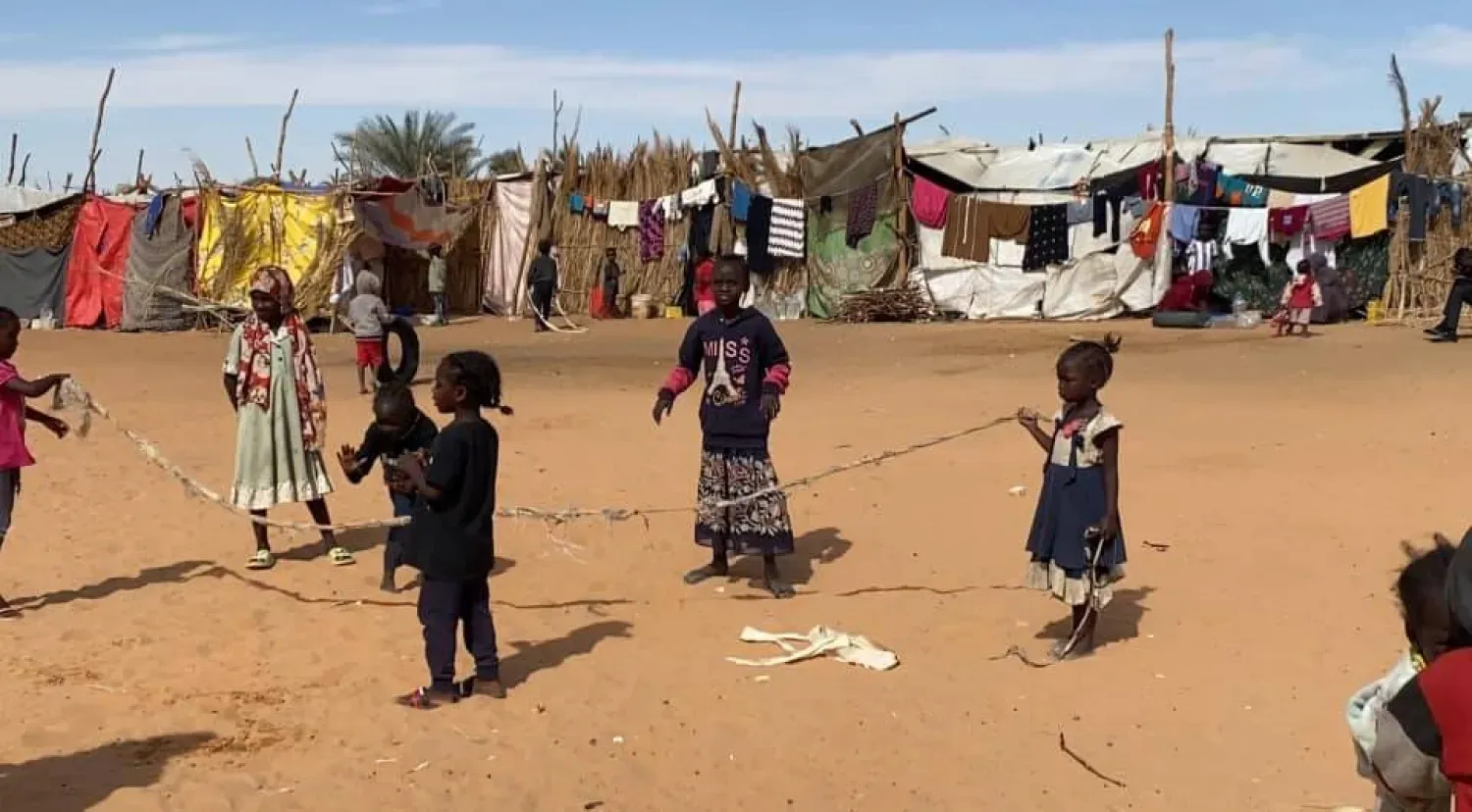 أطفال يلعبون أمام خيام للنازحين السودانيين على أطراف مدينة الكفرة الليبية (الصفحة الرسمية لبلدية المدينة)