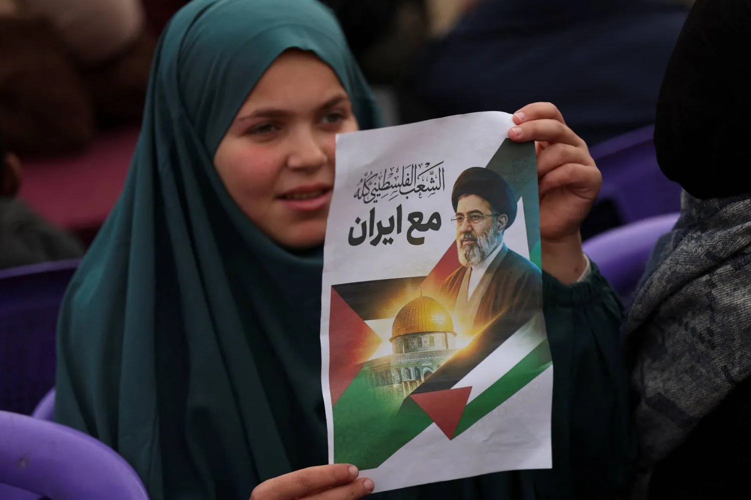 فلسطينية تحمل صورة لمجتبى خامنئي خلال إحياء «يوم القدس» في غزة (رويترز)