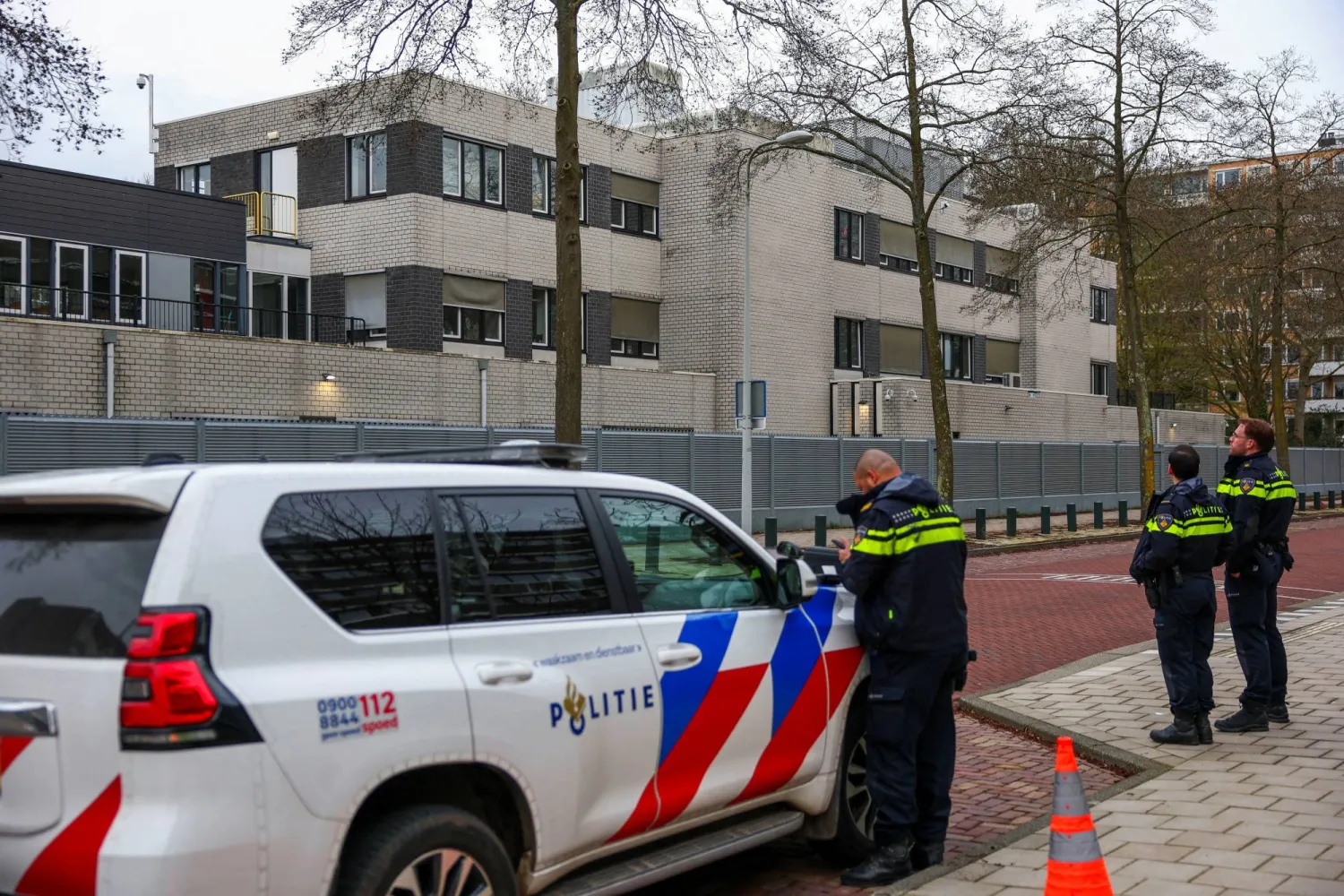 Police officers stand outside a Jewish school following an explosion that caused minor damages, in Amsterdam, Netherlands, March 14, 2026. REUTERS/Piroschka van de Wouw