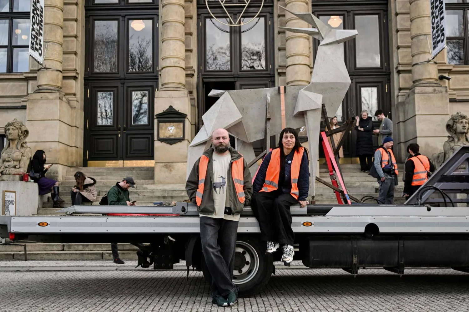 Ukrainian artist Zhanna Kadyrova (R) and Ukrainian curator of the 'Security Guarantees' project Leonid Marushchak pose in front of the 'Origami Deer' sculpture in Prague on March 12, 2026. (Photo by Michal Cizek / AFP)
