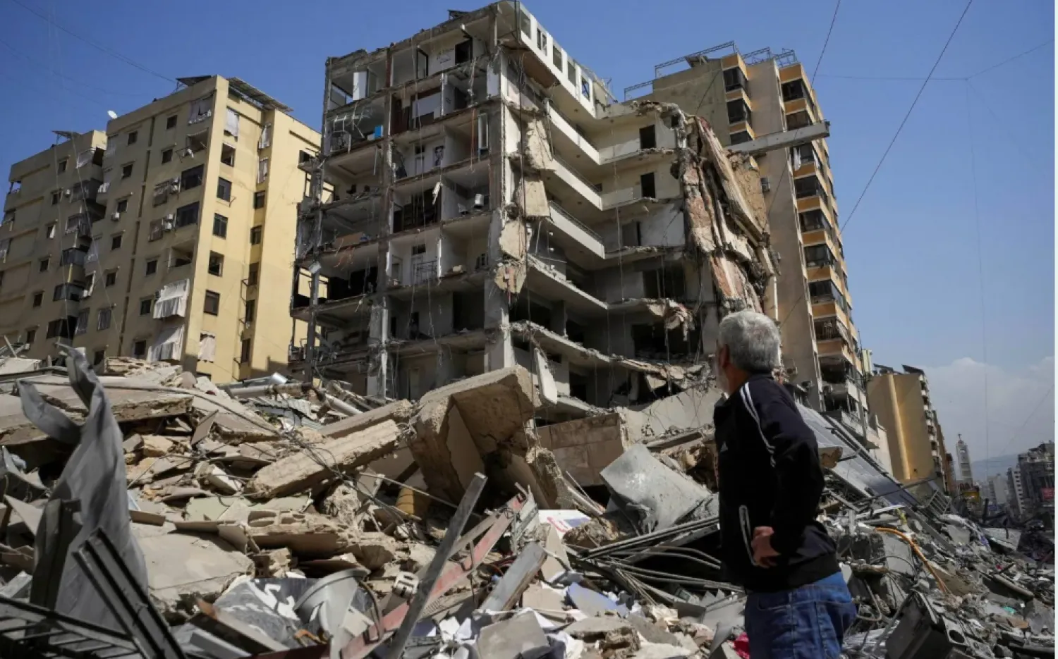 لبناني يسير قرب ركام مبانٍ دمرتها غارات إسرائيلية في ضاحية بيروت الجنوبية الشهر الحالي (رويترز)