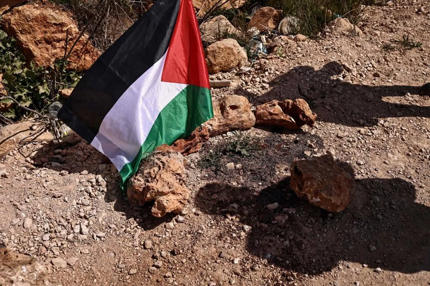 A Palestinian flag is placed at the site where a Jewish settlers' attack killed 3 Palestinians and injured seven others on March 8, in the village of Abu Falah, northeast of Ramallah in the Israeli-occupied West Bank on March 12, 2026. (AFP)
