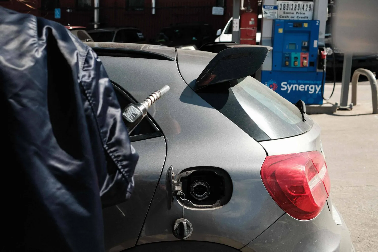  A woman holds a fuel pump as she fills her car tank at a gas station in the Manhattan borough of New York City on March 14, 2026. (AFP) 