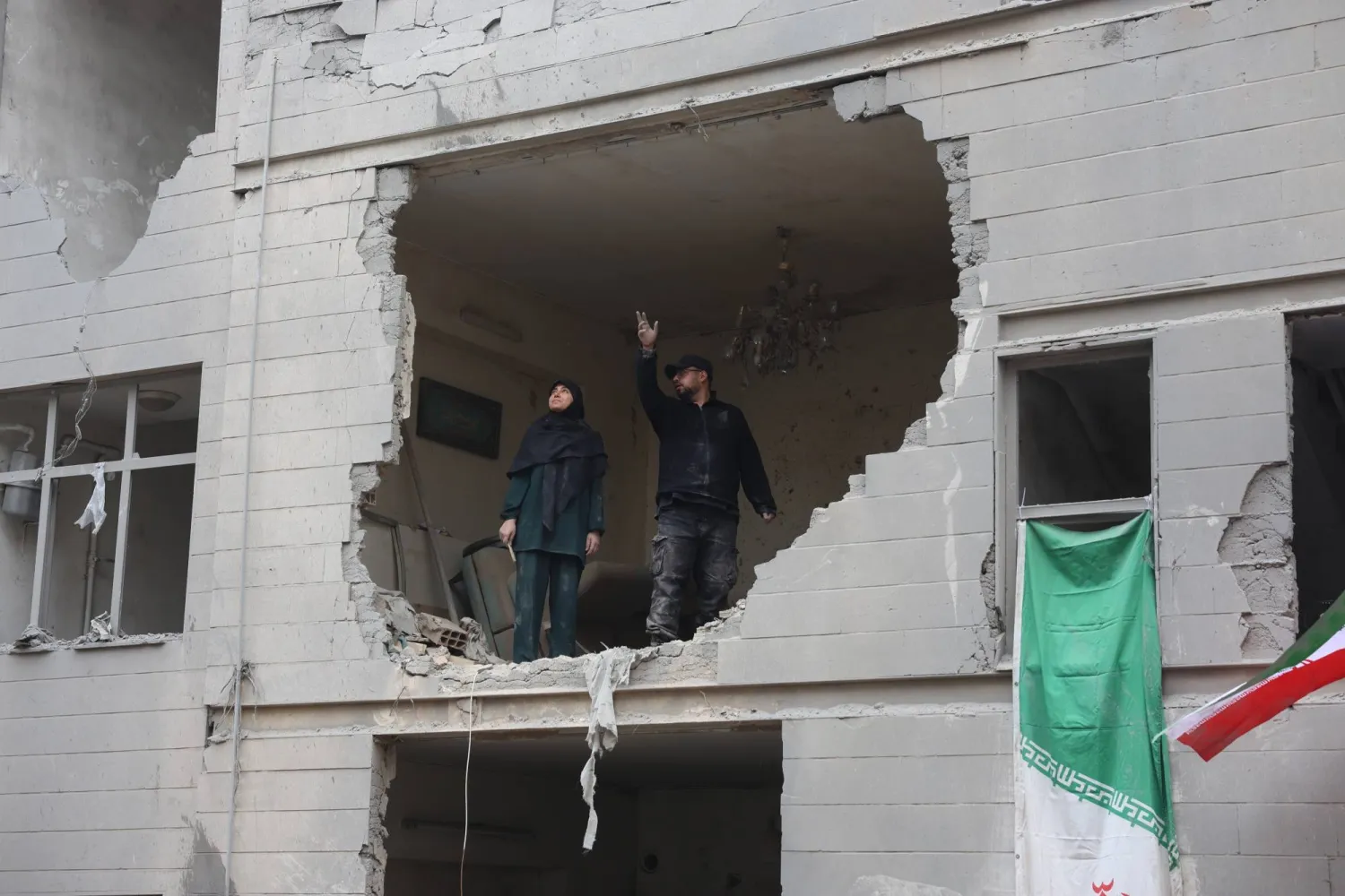 إيرانيان يقفان في منزلهما المدمر جزئياً جنوب طهران (إ.ب.أ)