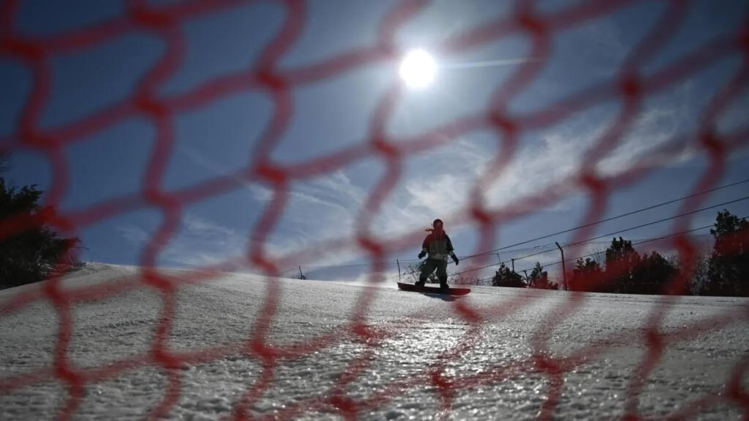 A visitor snowboards on the slopes at Lianhuashan Ski Resort on the outskirts of Beijing. Pedro PARDO / AFP
