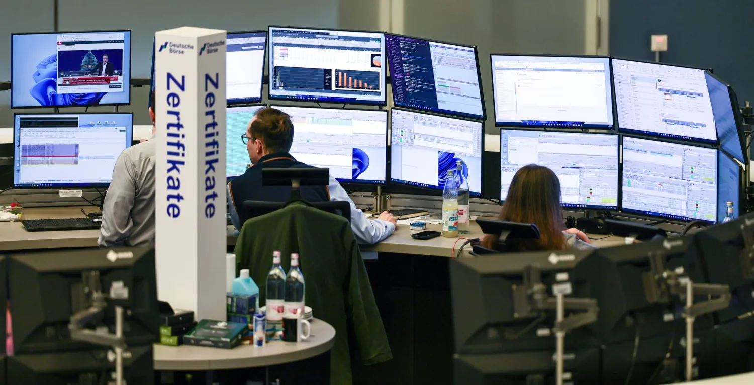 متداولون يراقبون شاشات الأسهم في قاعة التداول ببورصة فرنكفورت (إ.ب.أ)