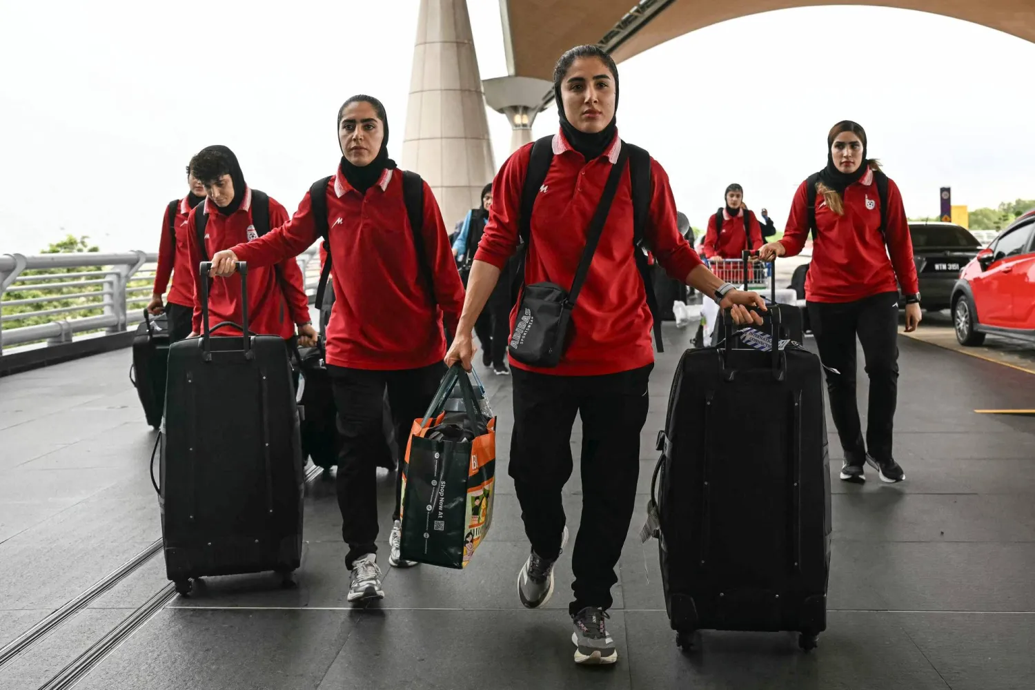 Members of Iran's women's football team arrive at the Kuala Lumpur International Airport in Sepang on March 16, 2026, after staying in a hotel in the Malaysian capital while awaiting the next leg of their journey home. (Photo by MOHD RASFAN / AFP)