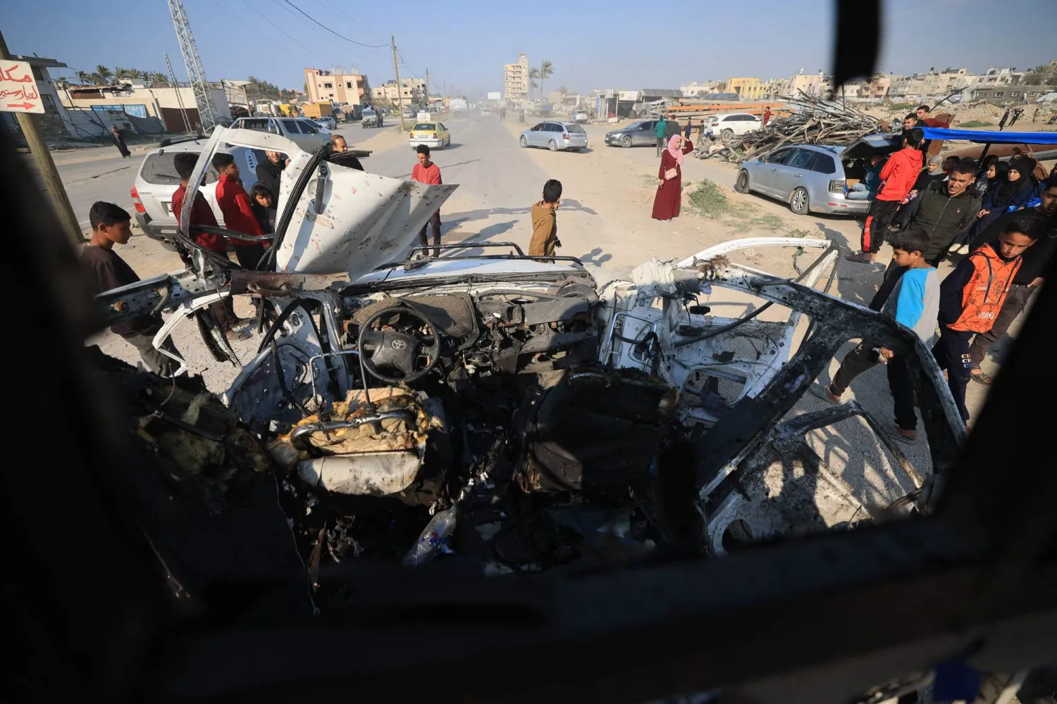 Palestinians inspect the site of an Israeli strike that targeted a police vehicle in Zawaida in the central Gaza Strip on March 15, 2026. (Photo by Eyad Baba / AFP)