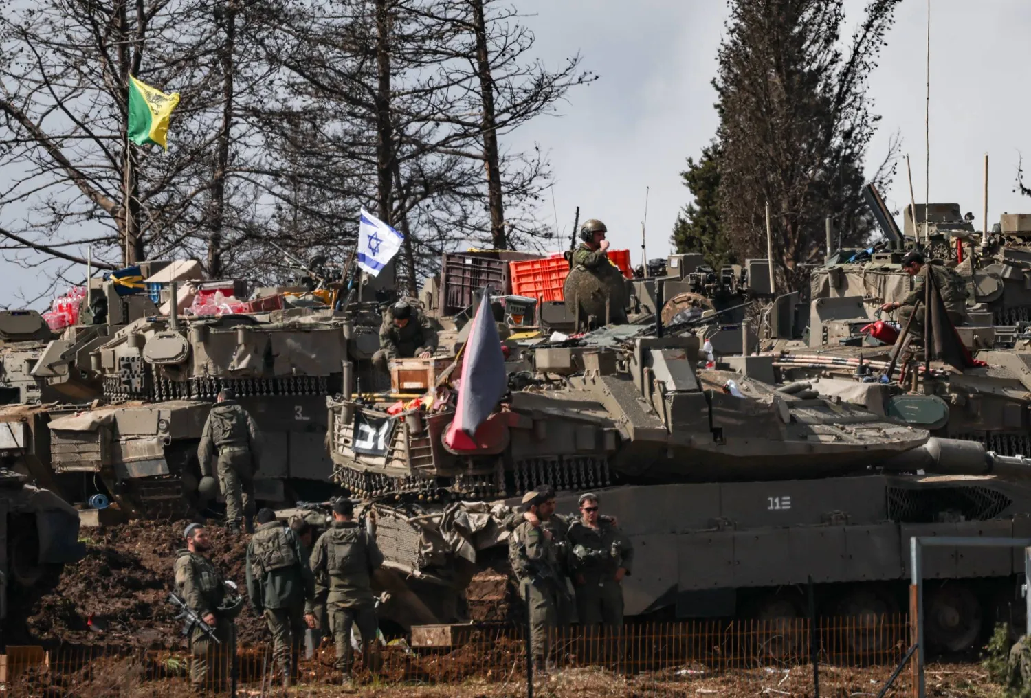 جنود إسرائيليون إلى جانب الآليات العسكرية عند الحدود اللبنانية مع إعلان تل أبيب بدء عملية برية محدودة (رويترز)