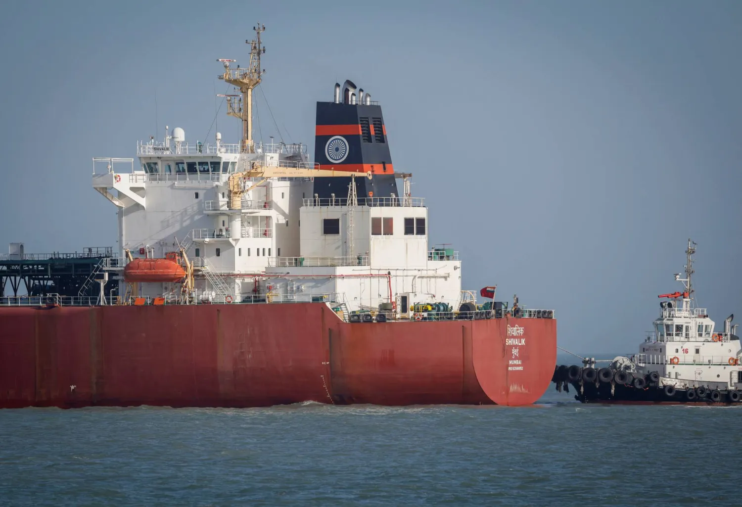 قارب تابع لخفر السواحل يقترب من ناقلة الغاز المسال الهندية «شيفاليك» لدى وصولها إلى ميناء موندرا عبر مضيق هرمز... الهند في 16 مارس 2026 (رويترز)