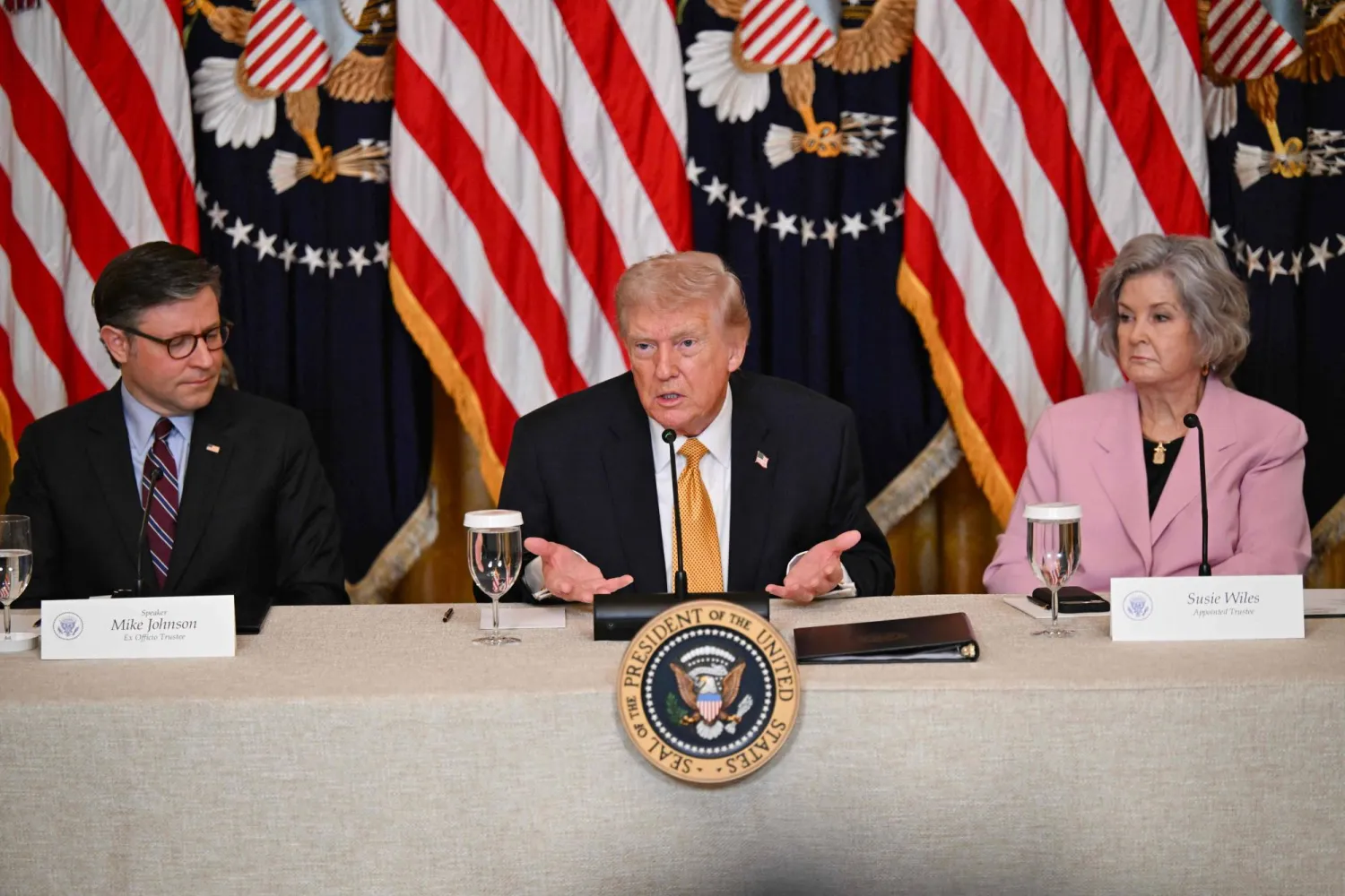 الرئيس الأميركي دونالد ترمب بين سوزي وايلز ورئيس مجلس النواب مايك جونسون (أ.ف.ب)