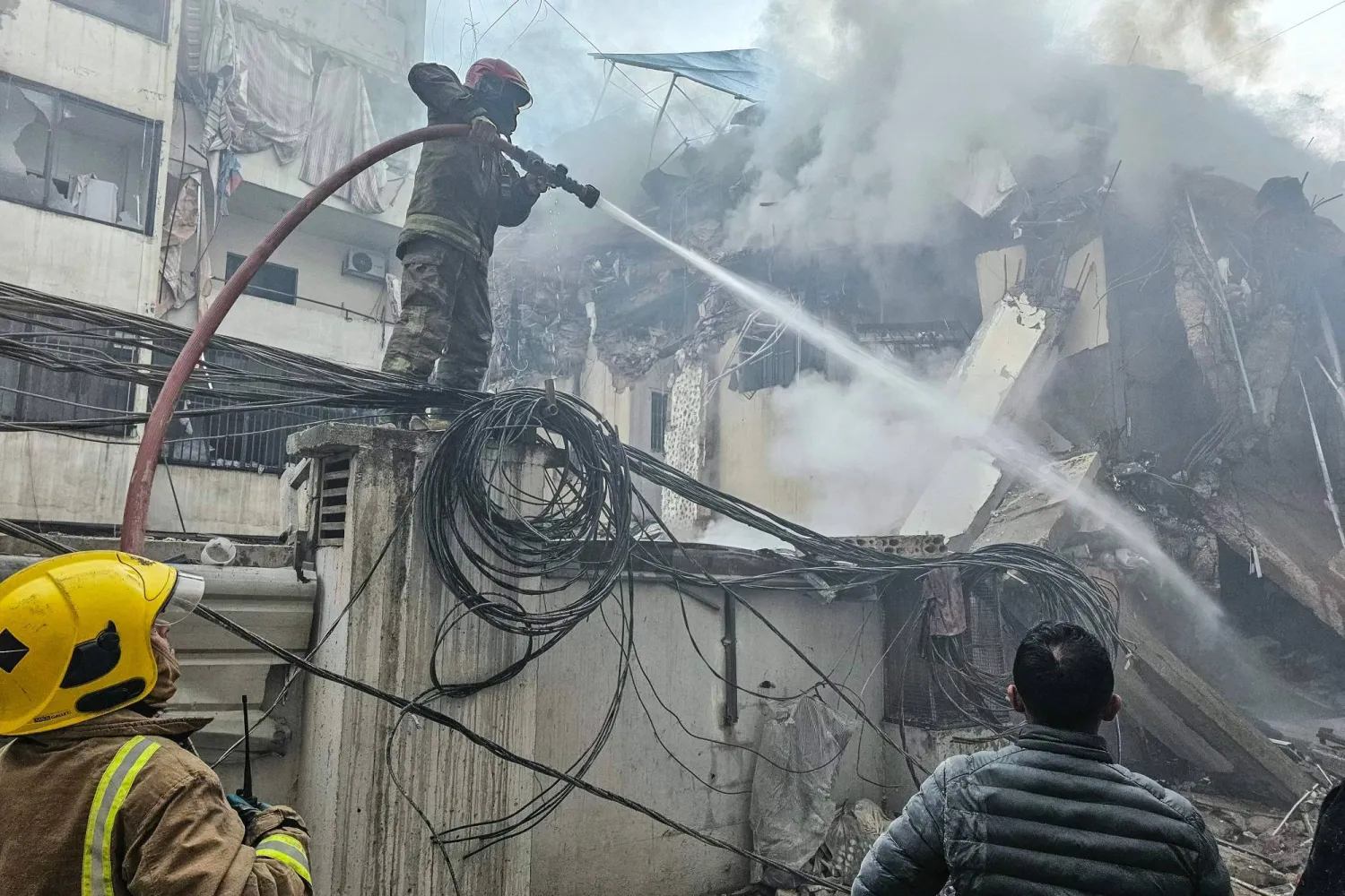 رجال الإطفاء يحاولون إخماد الحريق الذي اندلع في موقع غارة جوية إسرائيلية استهدفت ضاحية بيروت الجنوبية في الكفاءات (أ.ف.ب)