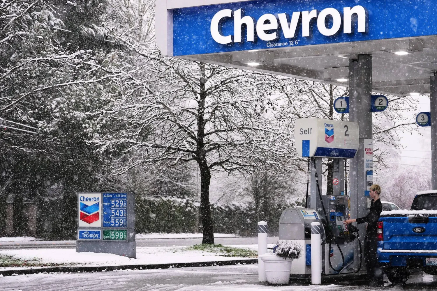 زبون يتزود بالوقود في محطة تابعة لـ«شيفرون» بواشنطن (أ.ب)