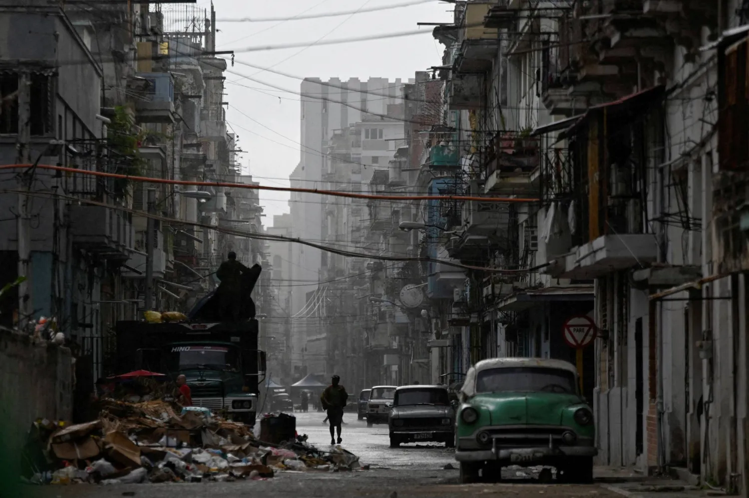 A man walks on a street in the rain as Cuba reconnected its electrical grid across much of the island, according to the Energy and Mines Ministry, following a nationwide blackout that left about 10 million people without electricity, in Havana, Cuba, March 17, 2026. (Reuters)