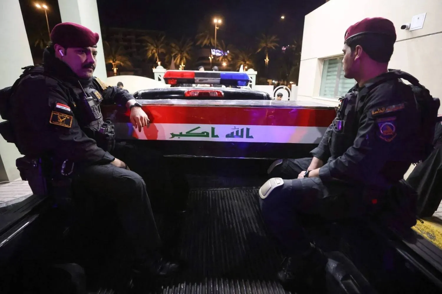 Iraqi security personnel stand beside the coffin of a Popular Mobilization Forces member killed in an attack in al-Qaim district (AFP)