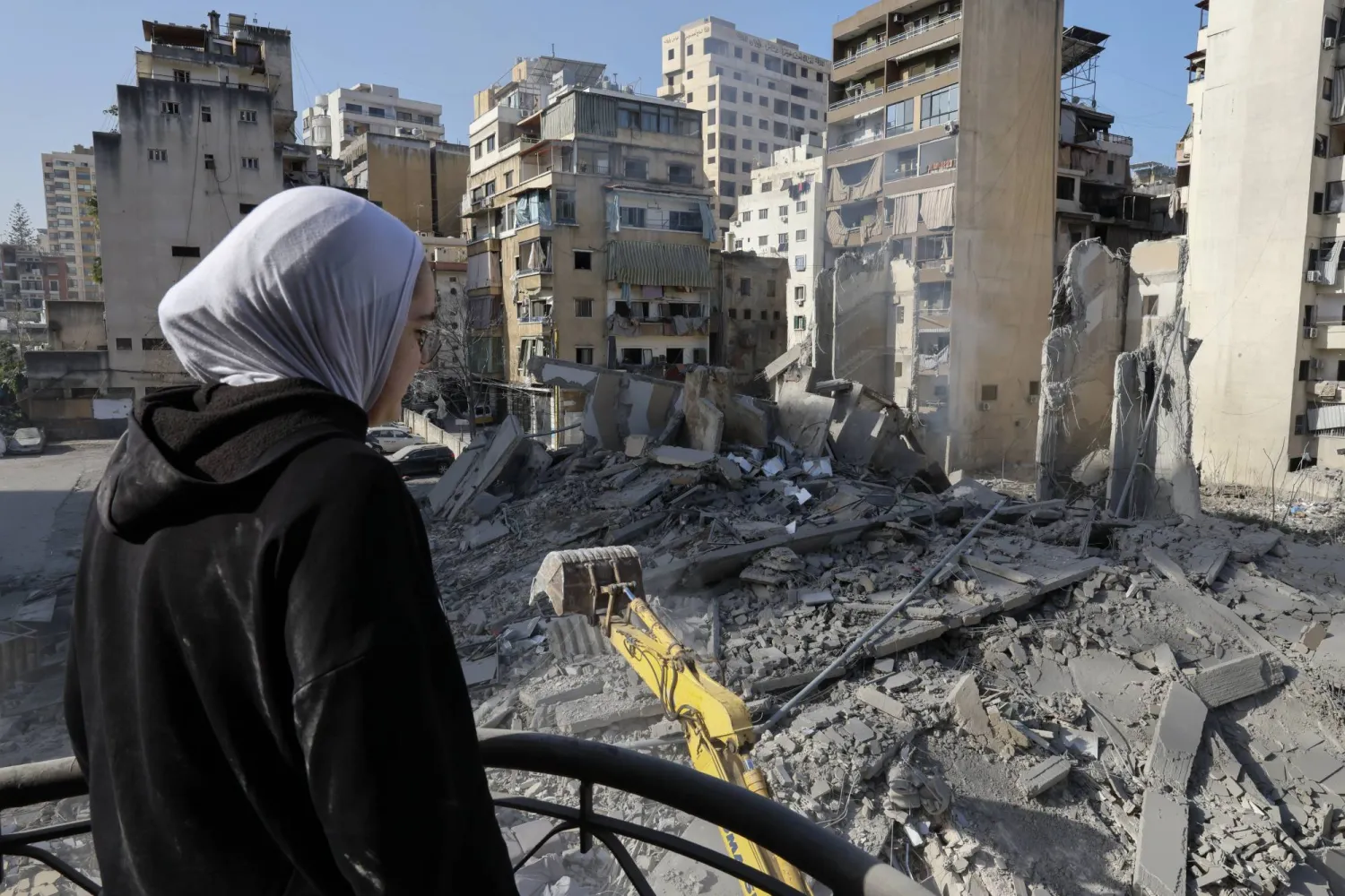 فتاة تنظر إلى موقع مبنى دمرته غارة إسرائيلية بالكامل في منطقة الباشورة في وسط بيروت (إ.ب.أ)