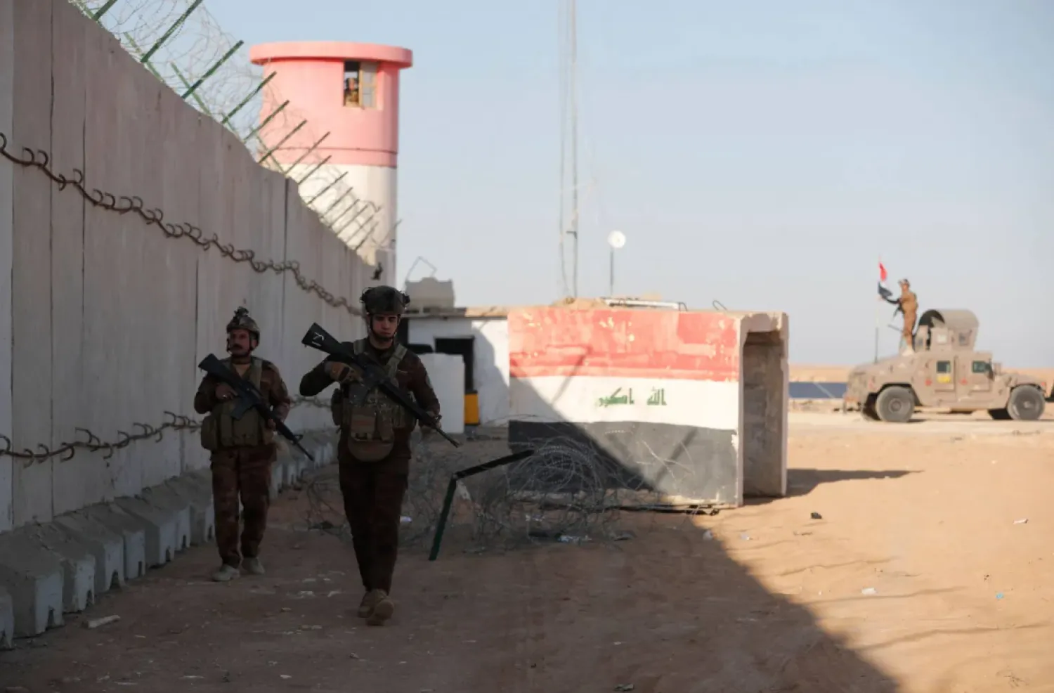 Members of the Iraqi border forces patrol along a concrete wall on the Iraqi-Syrian border, in the town of al-Baghuz in the Al-Qaim district of western Iraq, on January 21, 2026. (AFP)
