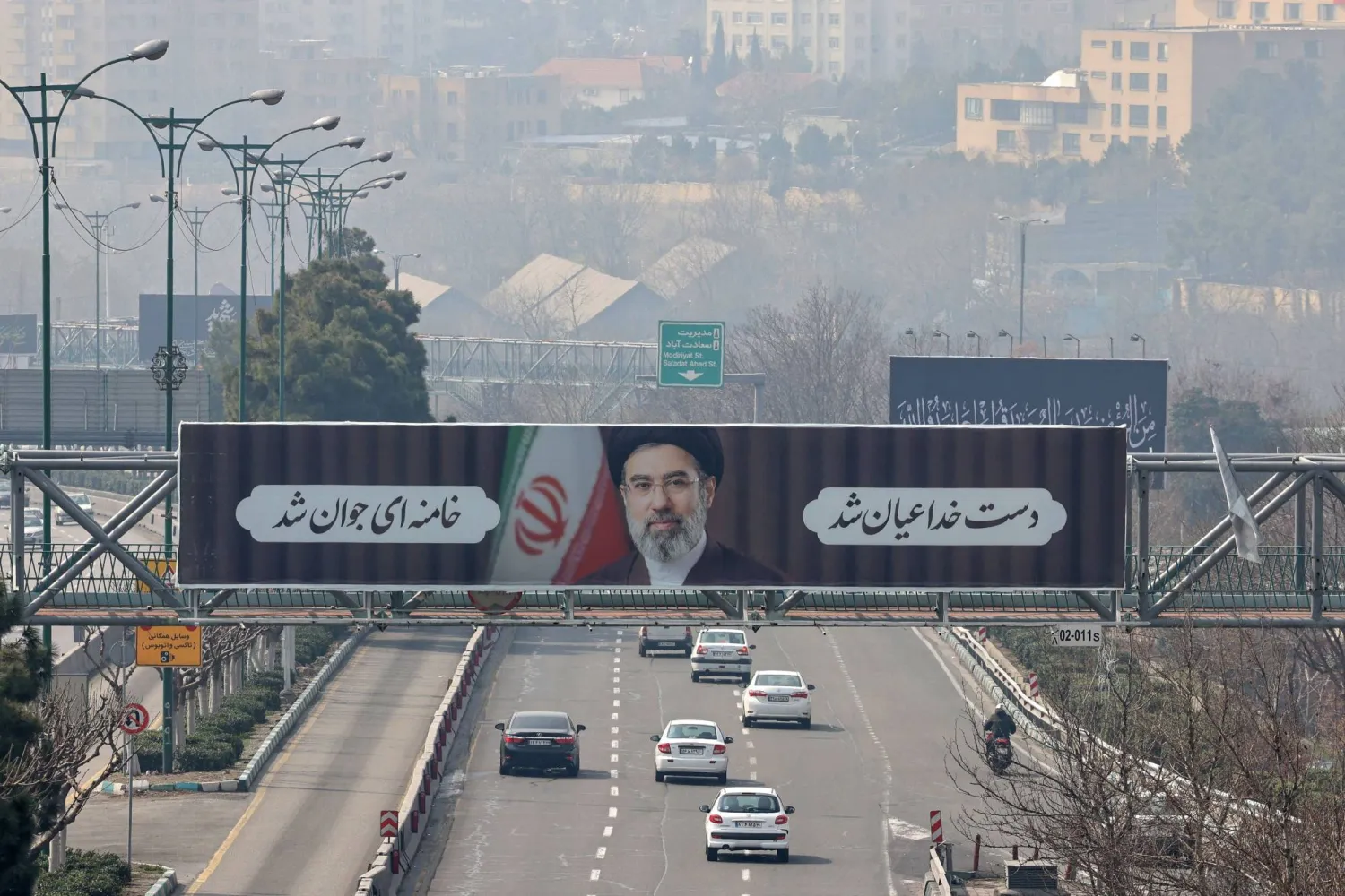 Motorists drive past a billboard of Iran's new supreme leader Ayatollah Mojtaba Khamenei in Tehran on March 14, 2026. (Photo by ATTA KENARE / AFP)