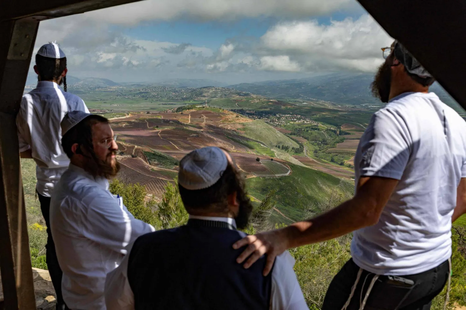مجموعة من اليهود المتشددين يراقبون آثار القصف على جنوب لبنان من نقطة مشرفة في الجليل الأعلى (أ.ف.ب)