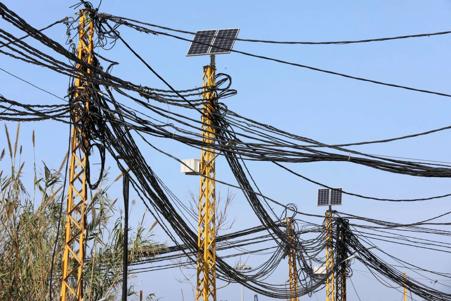 كابلات كهربائية متصلة بأعمدة كهرباء في بيروت يوم 18 فبراير 2022 (رويترز)