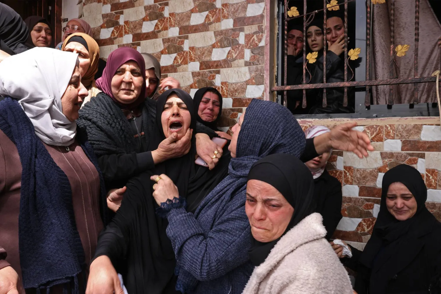 Family members mourn the death of one of the three Palestinian women killed in Iranian missile attacks, in Beit Awa town near the occupied West Bank city of Hebron on March 19, 2026. (AFP)
