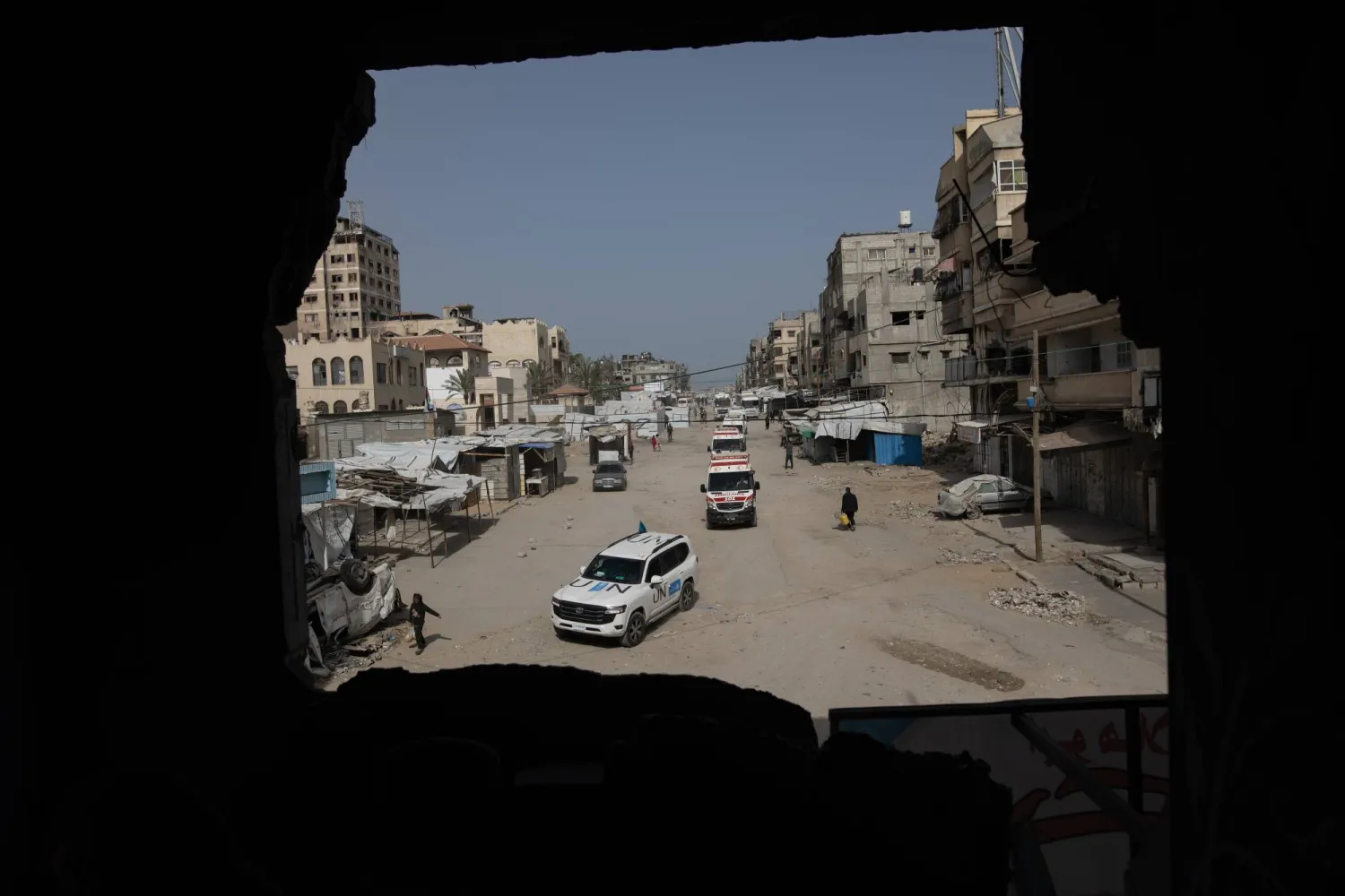 سيارات تحمل أول مجموعة من الجرحى يغادرون مقر الصليب الأحمر الفلسطيني في خان يونس متجهين إلى معبر رفح الحدودي مع مصر (إ.ب.أ)