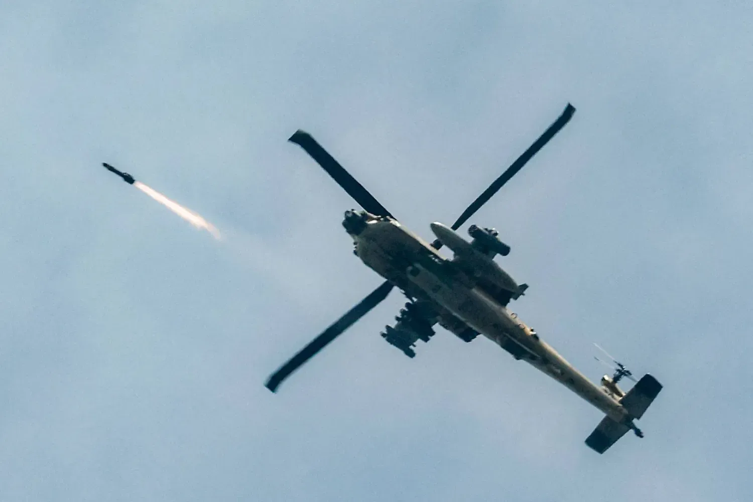 İsrail Hava Kuvvetlerine ait bir AH-64 Apache saldırı helikopteri, 18 Mart 2026'da kuzey İsrail ile güney Lübnan arasındaki sınır boyunca uçarken füze ateşliyor (AFP)