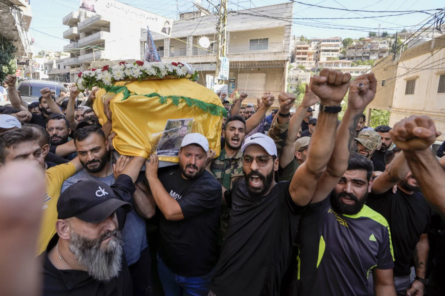 Mourners chant slogans as they carry the coffin of Ali Ahmad Mousawi, who was killed early Wednesday by an Israeli strike, during his funeral procession in Nabi Sheet village, in Lebanon's eastern Bekaa Valley, Wednesday, Aug. 21, 2024.   (AP Photo/Bilal Hussein)