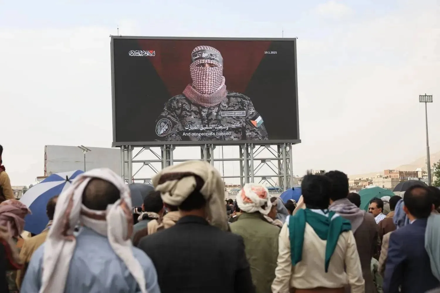 Yemenis watch a speech by “Abu Ubaida,” spokesman for the Qassam Brigades, whom Israel said it killed in August 2024 (file photo, EPA)

