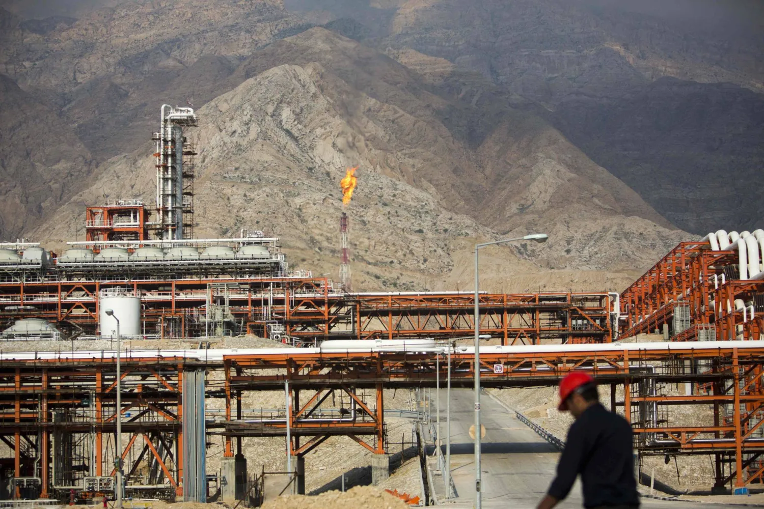 An Iranian man walks along the phase 15-16 of the South Pars gas field facilities in the southern Iranian port of Assaluyeh on the shore of the Gulf on January 22, 2014. (AFP)