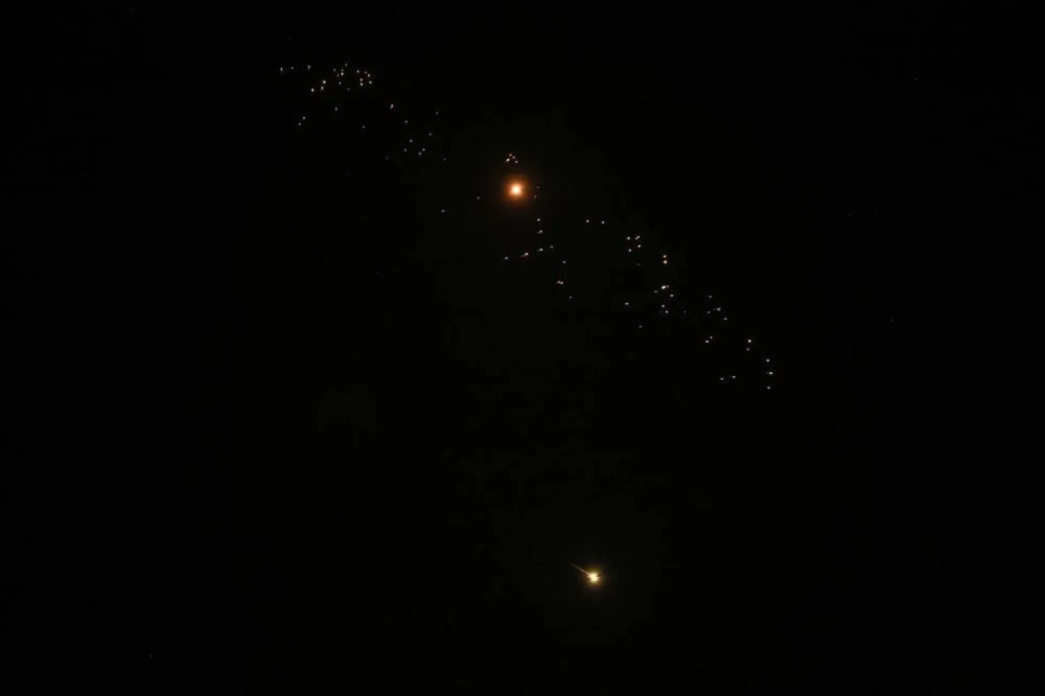  Streaks of fire and light cross the night sky as an Israeli interceptor strikes an Iranian missile amid the US-Israeli conflict with Iran, over Tel Aviv, Israel, March 18, 2026. (Reuters)