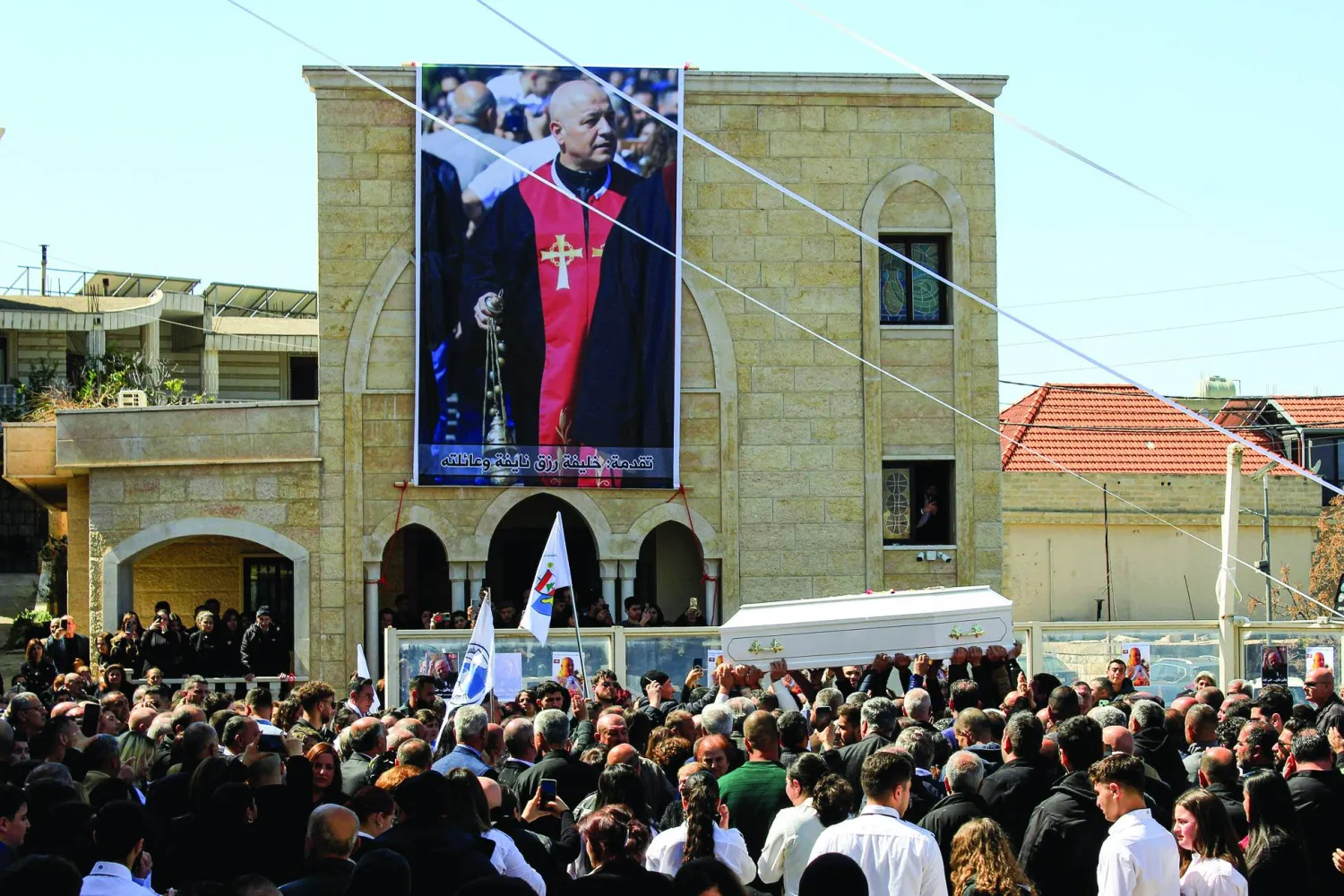 مسيحيون من بلدات مسيحية في جنوب لبنان يحملون نعش الأب بيار الراعي الذي قتل بنيران إسرائيلية في بلدته القليعة بجنوب لبنان (د.ب.أ)