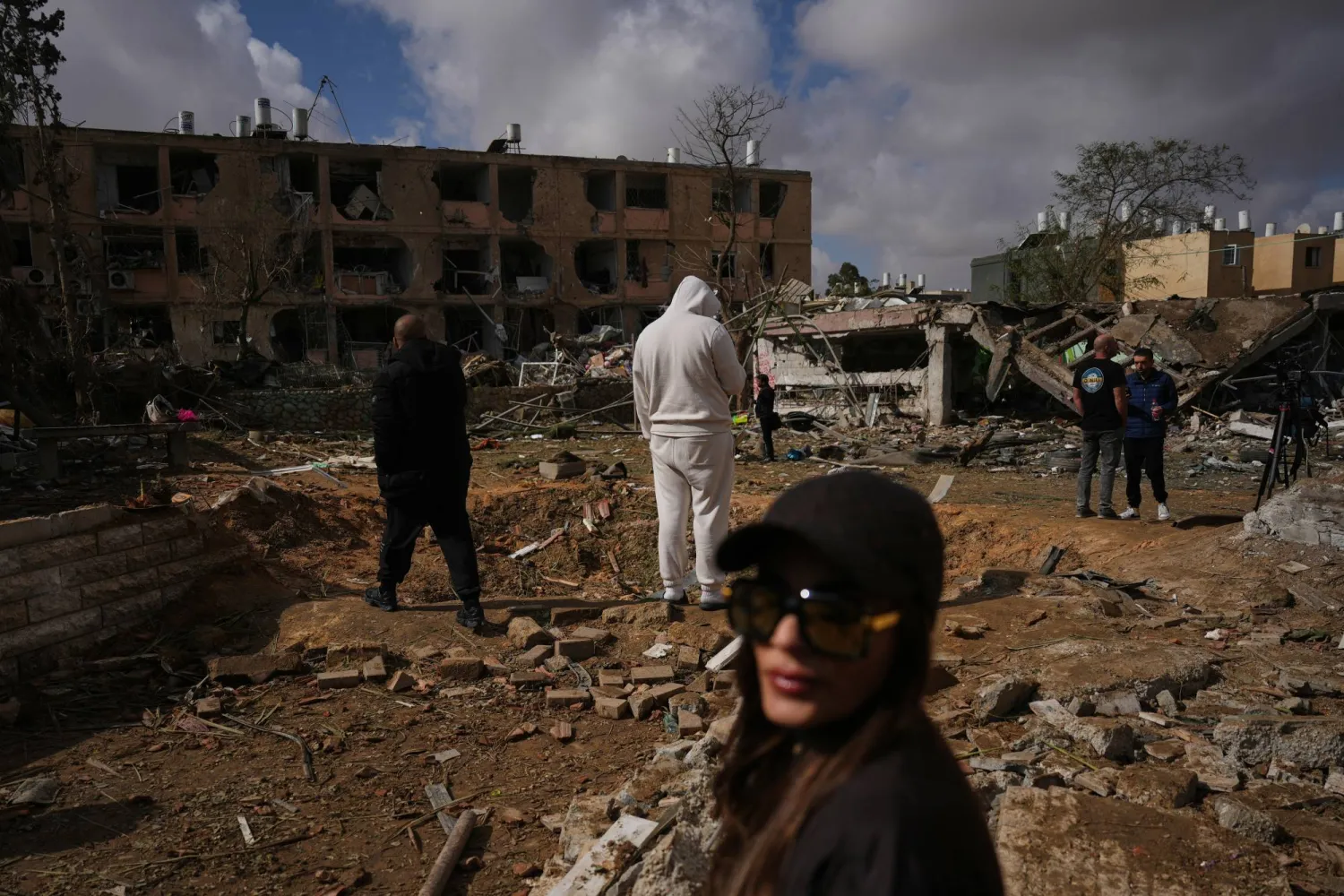 مواطنون يتفقدون أثر سقوط صاروخ إيراني في ديمونة جنوب إسرائيل اليوم (أ.ب)